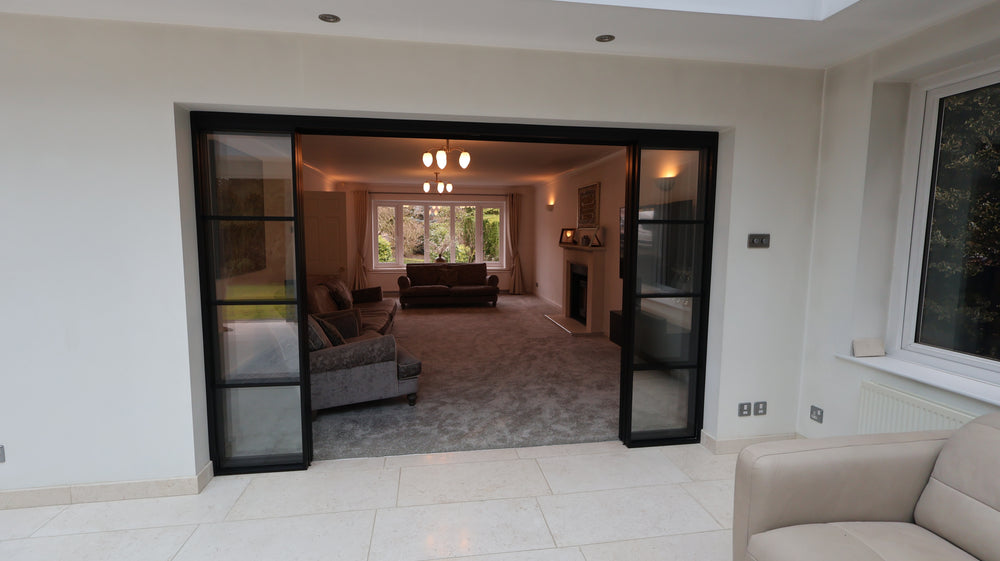 Living room with a sliding glass door leading to a conservatory