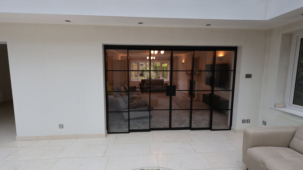 Modern living room with a large concertina sliding door leading to a conservatory in Altrincham