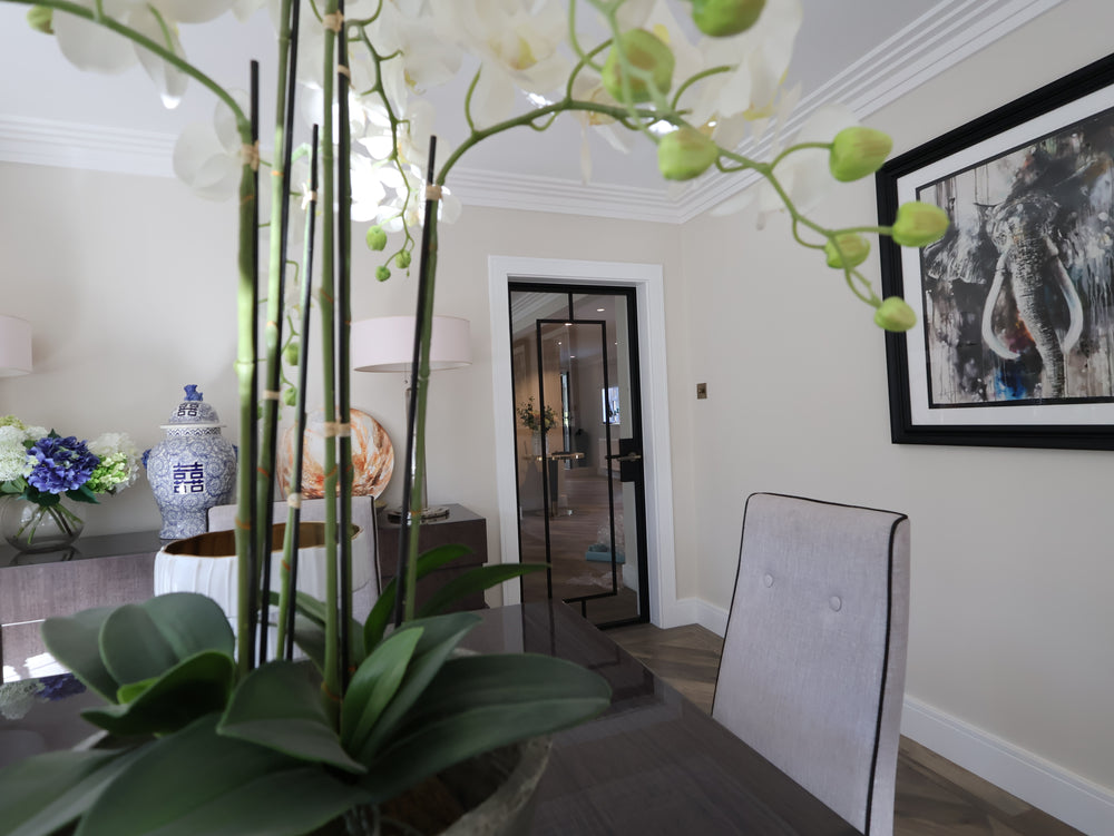 Black steel framed internal door with slim sightlines connecting open-plan living spaces in a contemporary Surrey home. Bespoke internal steel door finished in black powder coat.