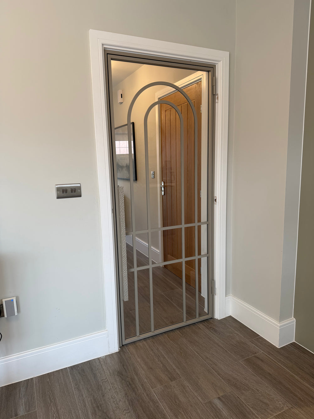 Single steel door with arched bars in Ivory Sands finish