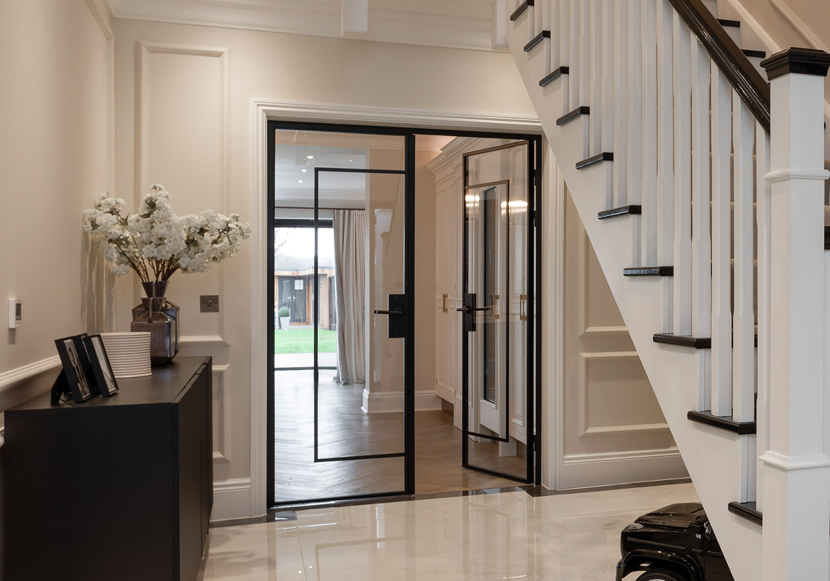 Modern interior with glass doors, staircase, and decorative elements.