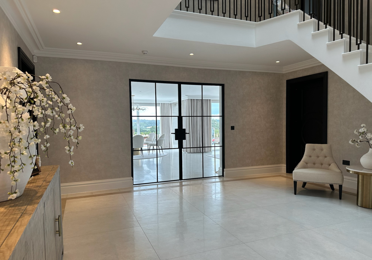 Modern interior with a staircase, glass doors, and decorative elements.