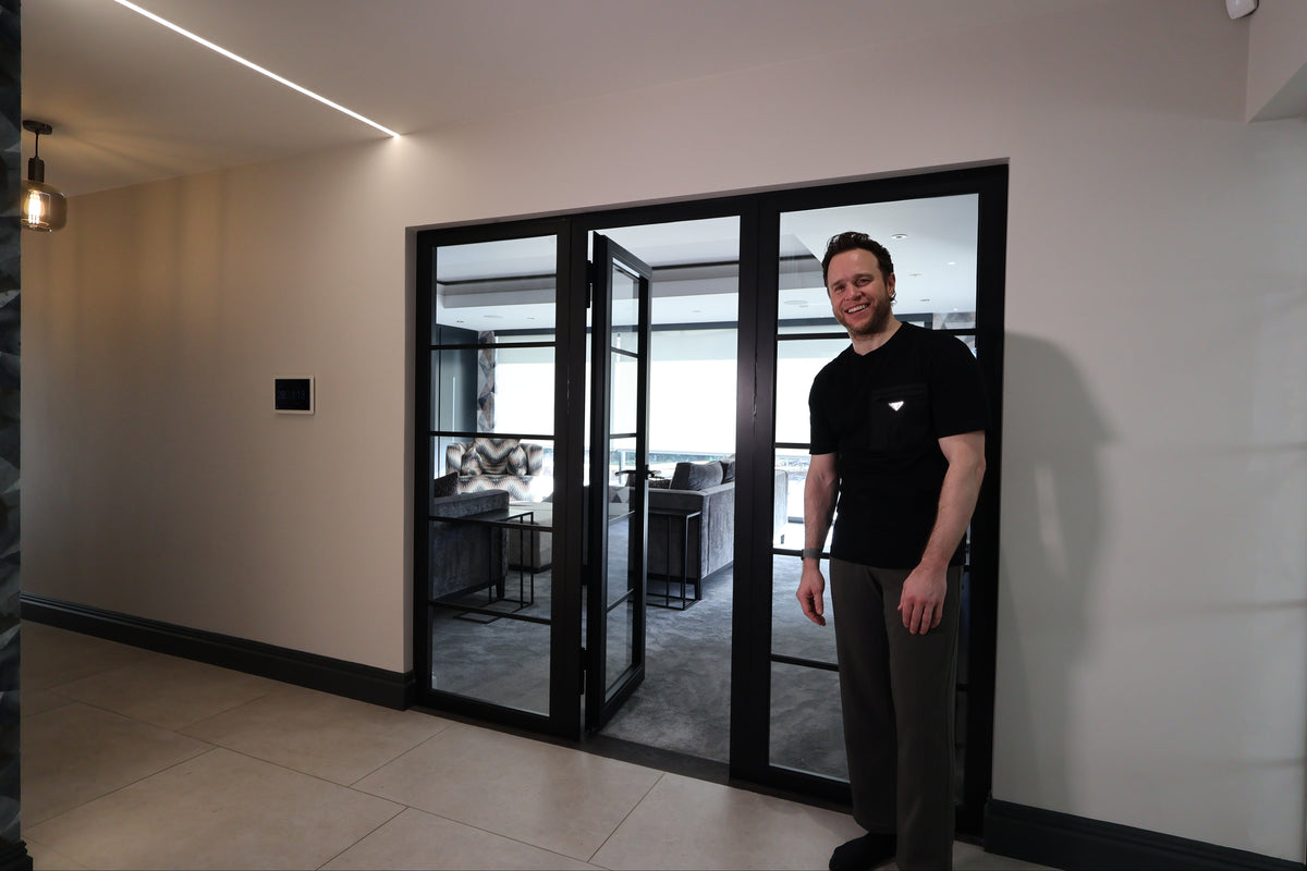 Olly Murs standing by his fire rated steel door installed by the Steel Door Company