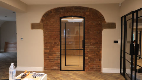 Single arched steel door with fluted glass