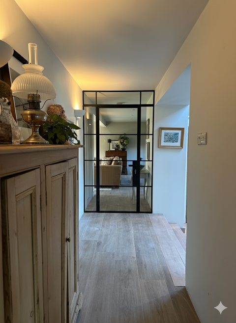 Single steel door with fixed side and top panels, designed to maximise natural light and create a striking architectural feature. Slim black steel frames provide a clean, modern finish while enhancing the sense of space.