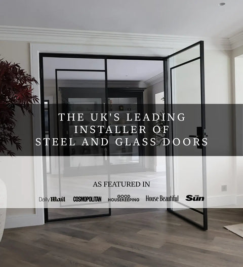 Black steel and glass interior doors installed in a modern room with wood flooring, featuring a large open door and a smaller inner door. A dark text banner overlays the center with promotional copy, and several magazine logos appear along the bottom.