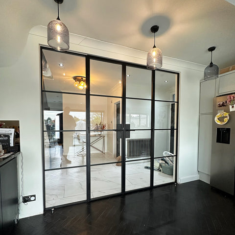 Steel double doors with fixed side panels, designed for wider openings and to maximise natural light throughout the home. Slim black steel frames create a bright, open feel while maintaining definition between spaces.