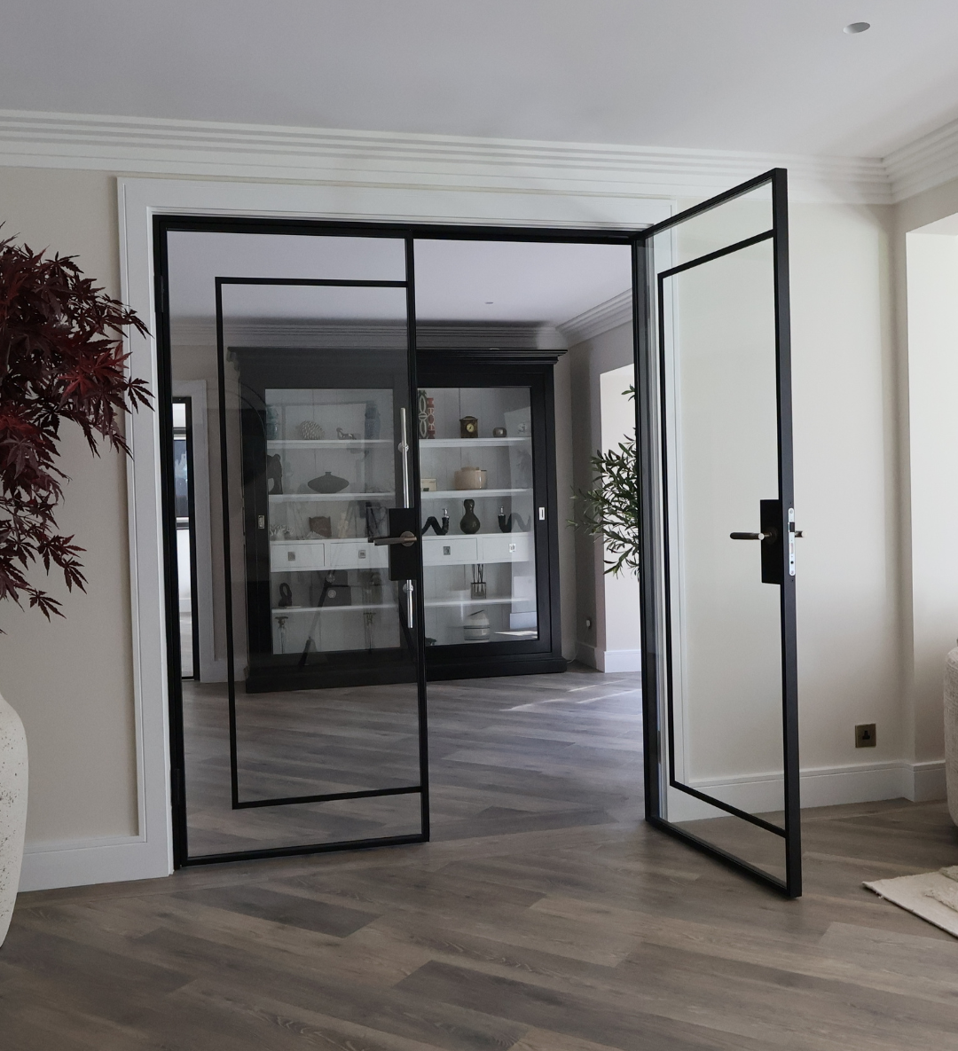 Slim black steel door with narrow sightlines in a contemporary interior setting.