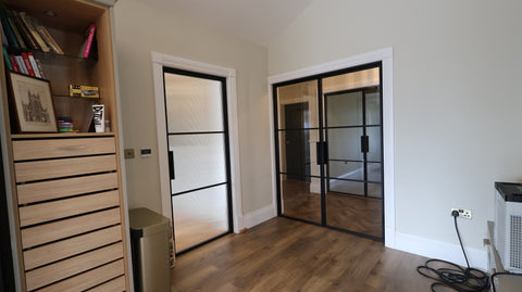 Black steel internal doors featuring a fluted glass pantry door and matching double doors with clear glazing leading into the kitchen