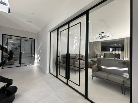 Glass doors in a modern interior, forming a steel framed partition that divides space while maintaining light and openness.